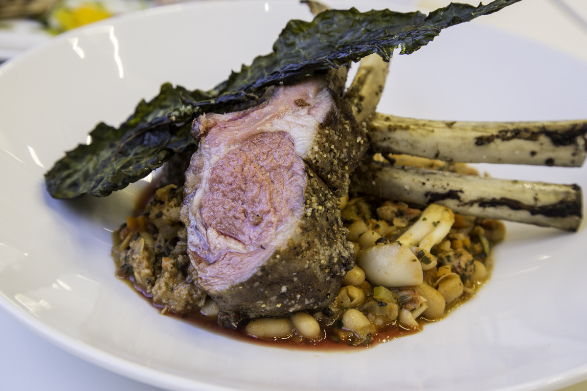 New Zealand rack of lamb, simply marinated with juniper berry and Italian spices, is served over a rustic stew of tomatoes, buttery Japanese mushrooms, Italian sausage and cannellini beans.